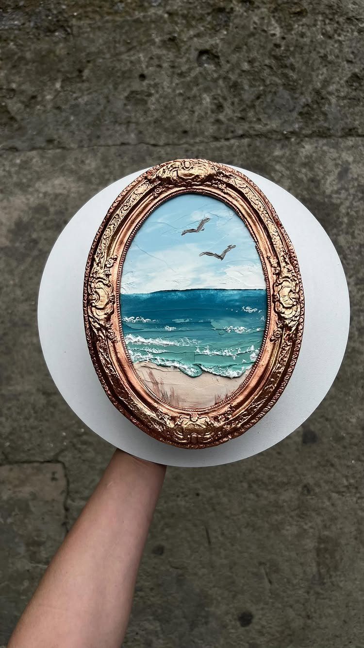 Beach scene cake with an ornate gold frame and blue ocean waves.