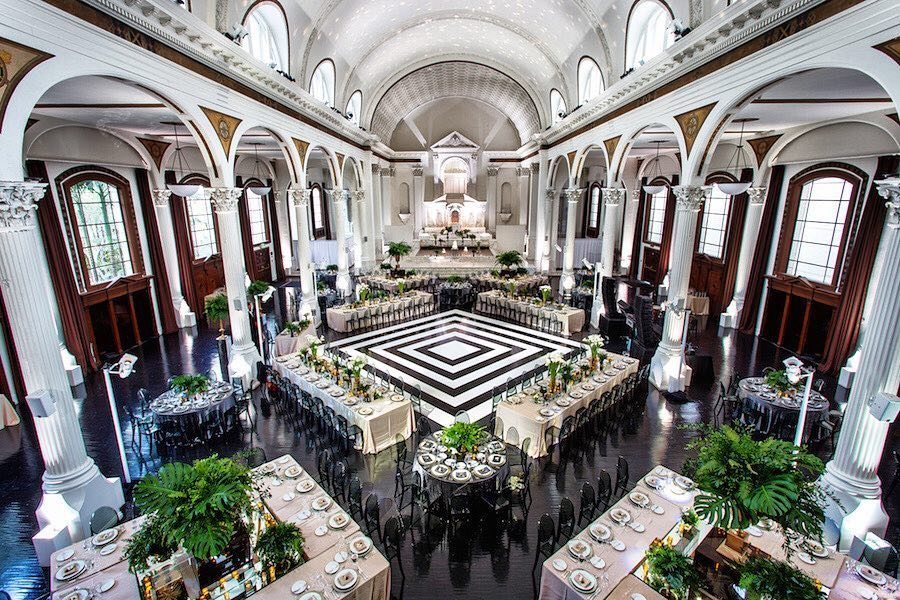 Grand white cathedral interior with banquet tables and a checkered black and white floor.