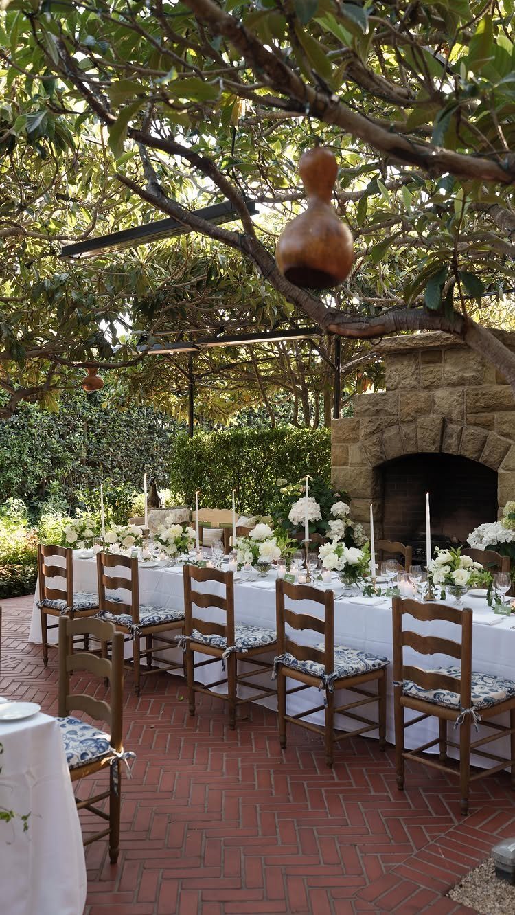 Outdoor wedding reception table with white flowers on a red brick patio