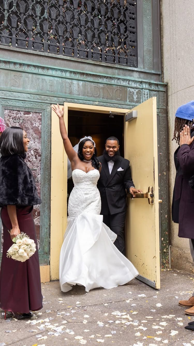Bride and groom celebrating as they exit a building after their wedding ceremony