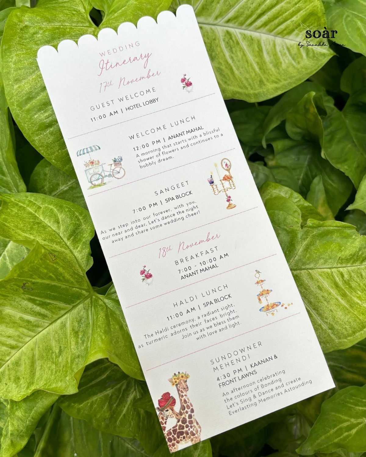 Wedding itinerary card with colorful illustrations resting on bright green tropical leaves.