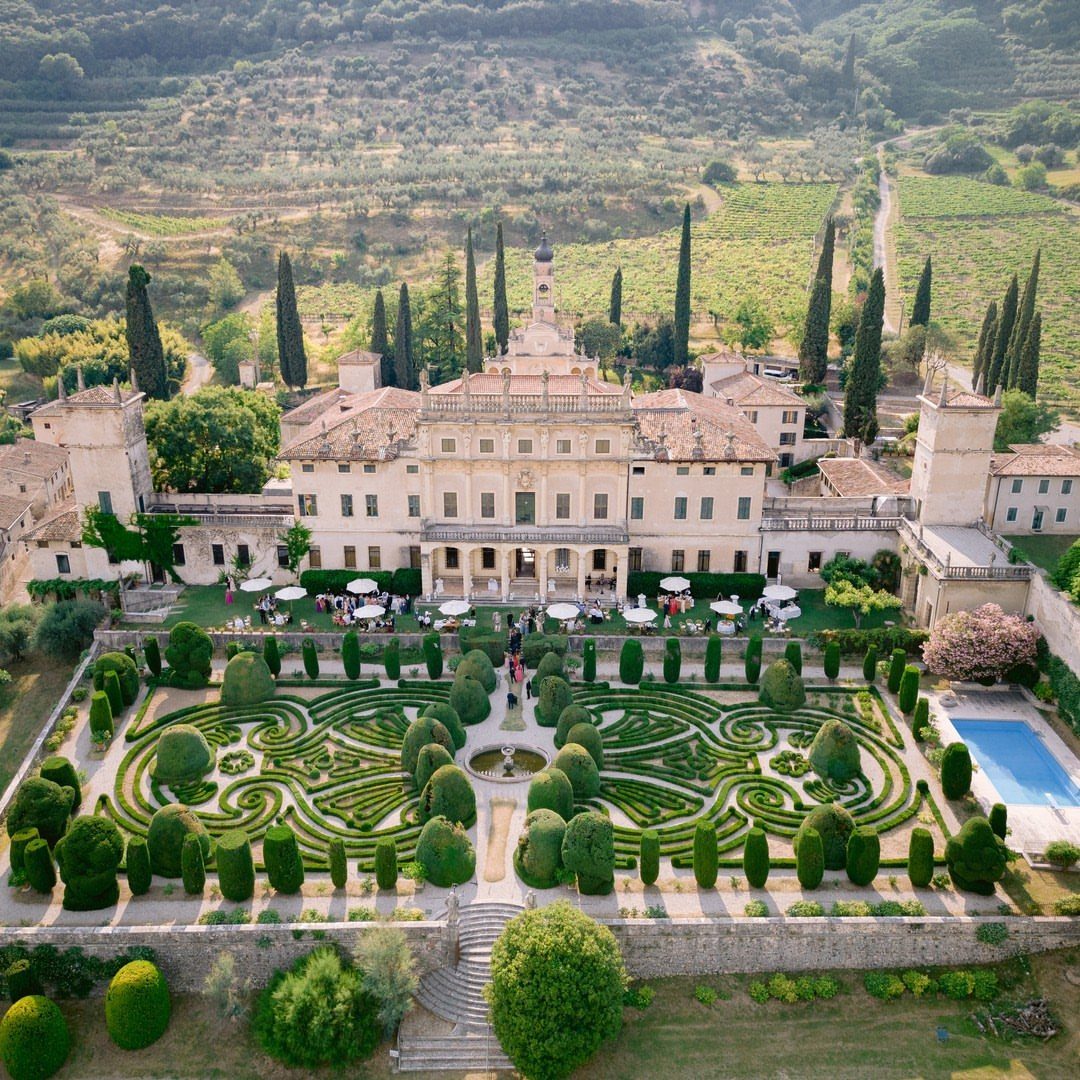 Grand Italian villa with a formal hedge maze garden and wedding guests.