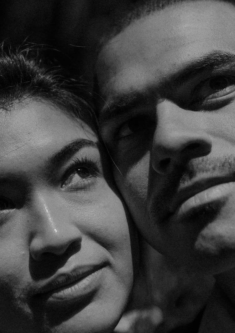 Close-up black and white portrait of a couple leaning their heads together.