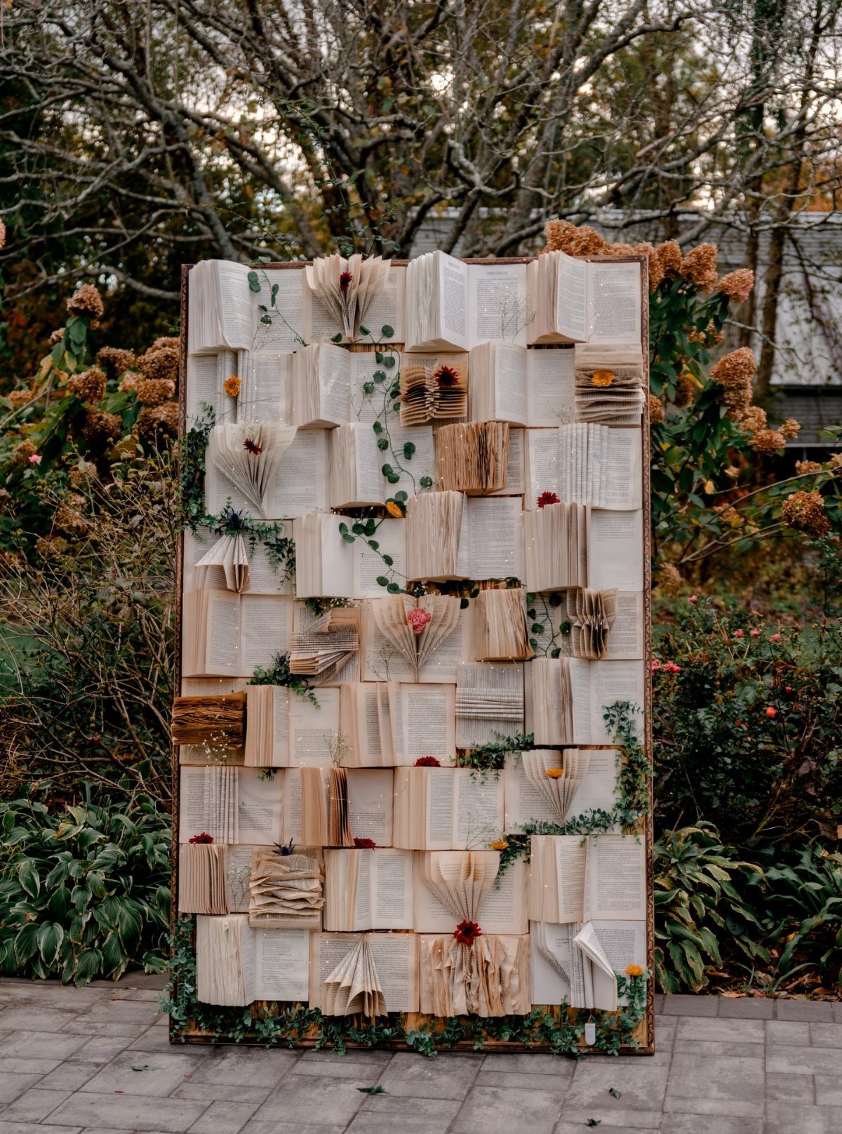 Book page backdrop with orange flowers and greenery in an outdoor garden setting