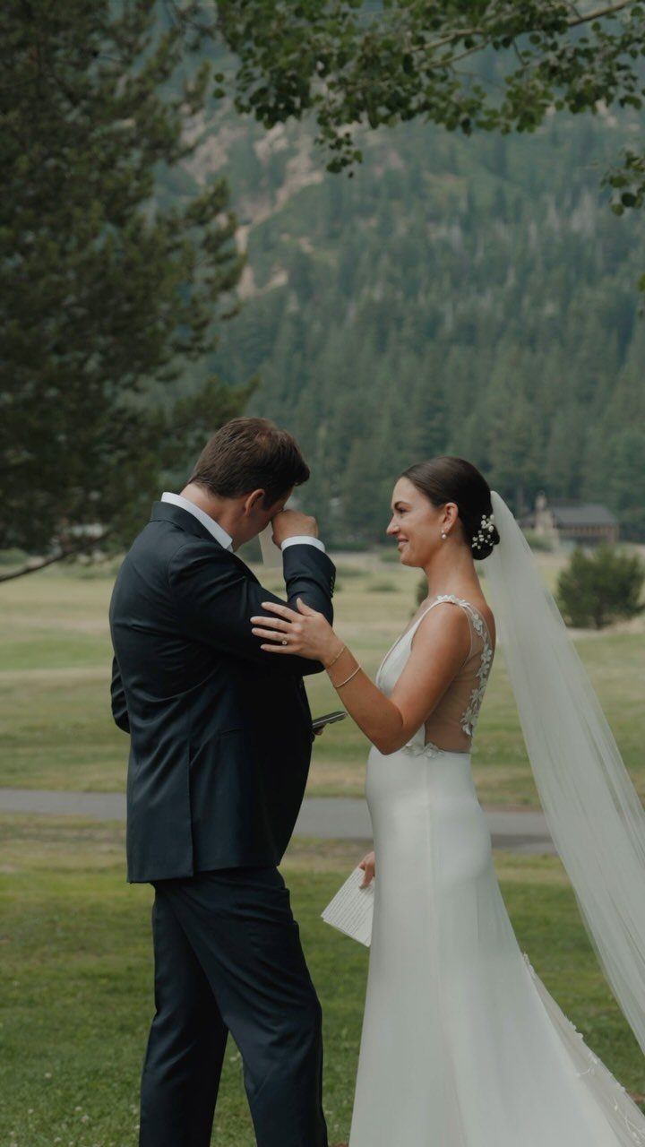 Bride and groom sharing a private moment in a grassy mountain meadow