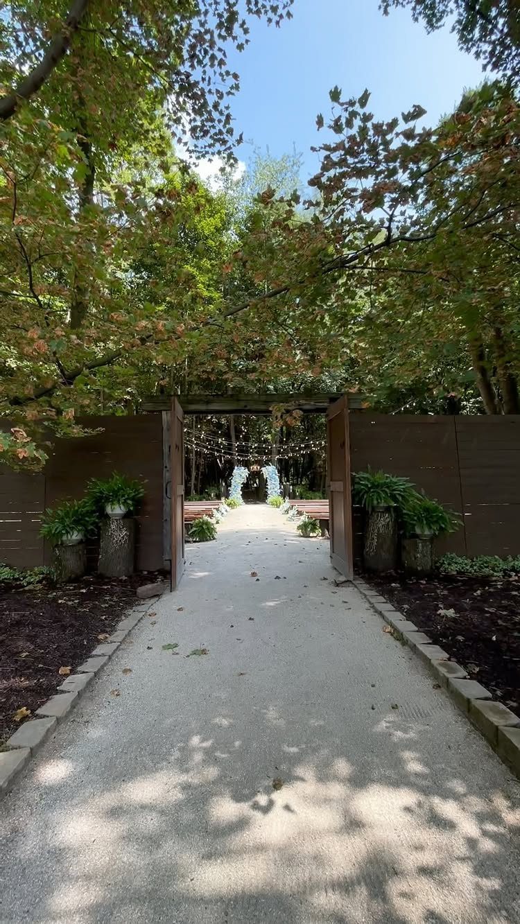 Gravel path leading to a wedding altar with benches in a forest setting