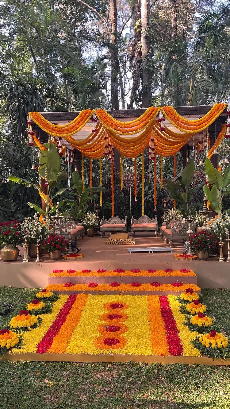 Outdoor Indian wedding venue with marigold garlands and a floral petal carpet.