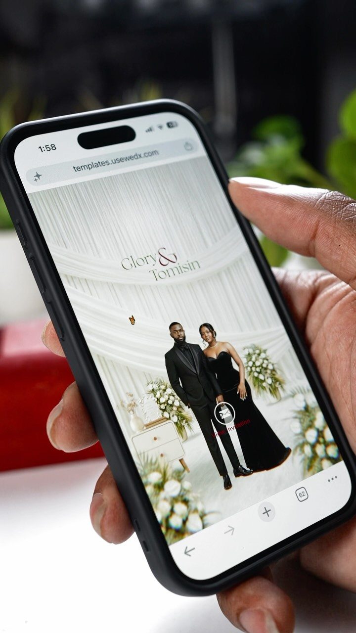 Smartphone screen displaying a wedding website with a couple and floral decor.