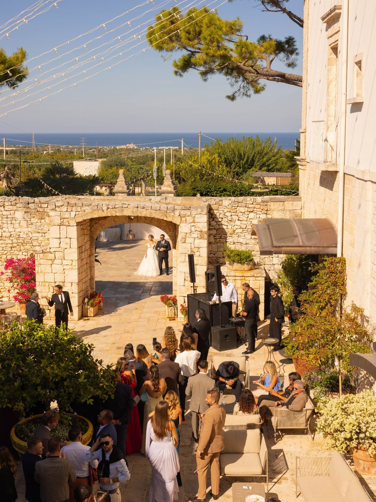 Wedding ceremony in a stone courtyard of a Puglia masseria overlooking the sea