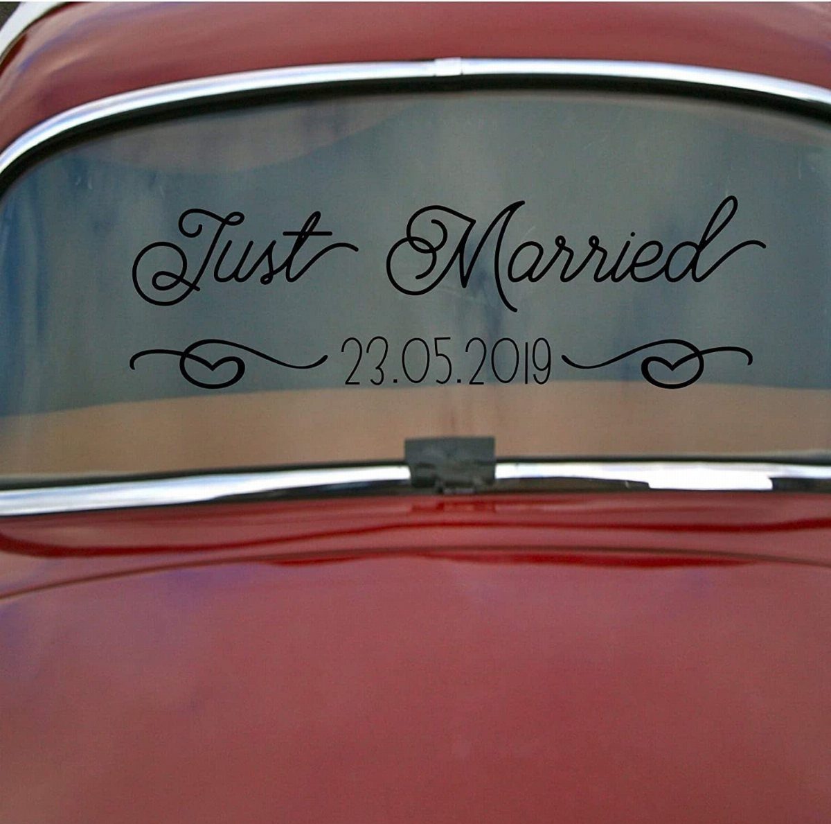 Black Just Married decal with a date on a red vintage car window