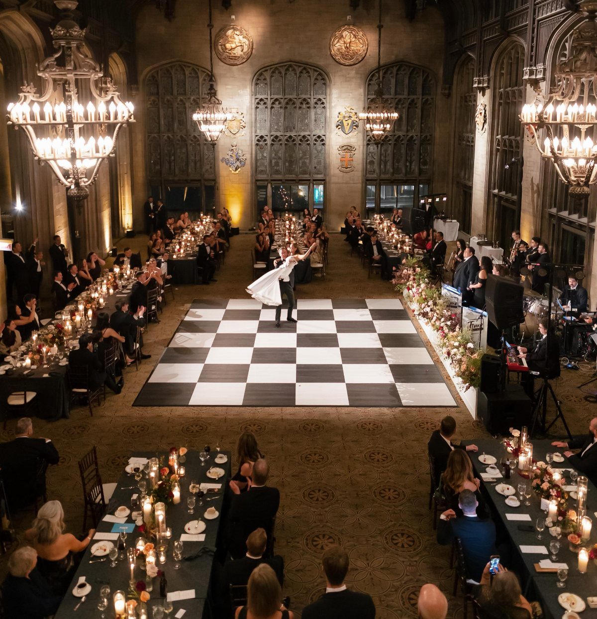 Bride and groom dancing on a checkered floor in a gothic luxury ballroom