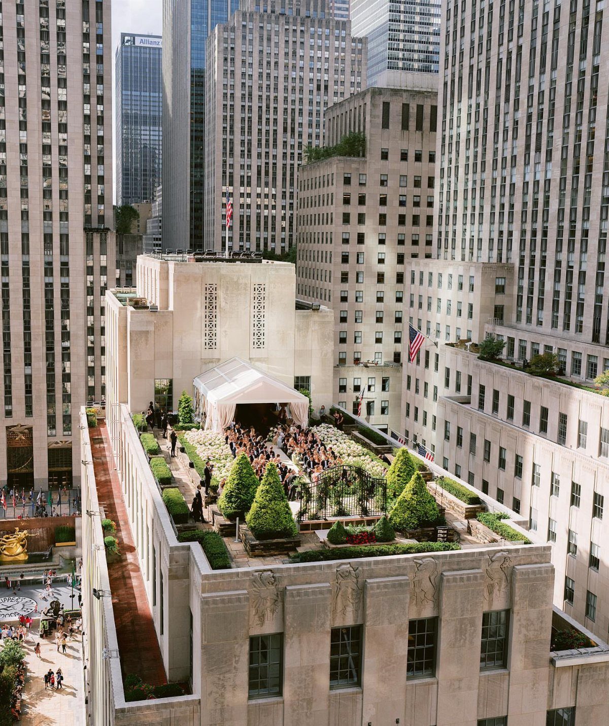 Rooftop terrace with a white event tent and guests surrounded by Manhattan skyscrapers.