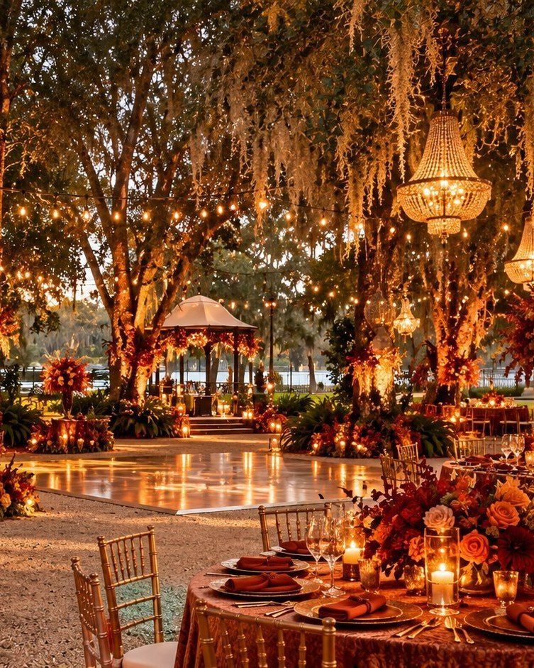 Outdoor wedding reception with crystal chandeliers and string lights hanging from oak trees