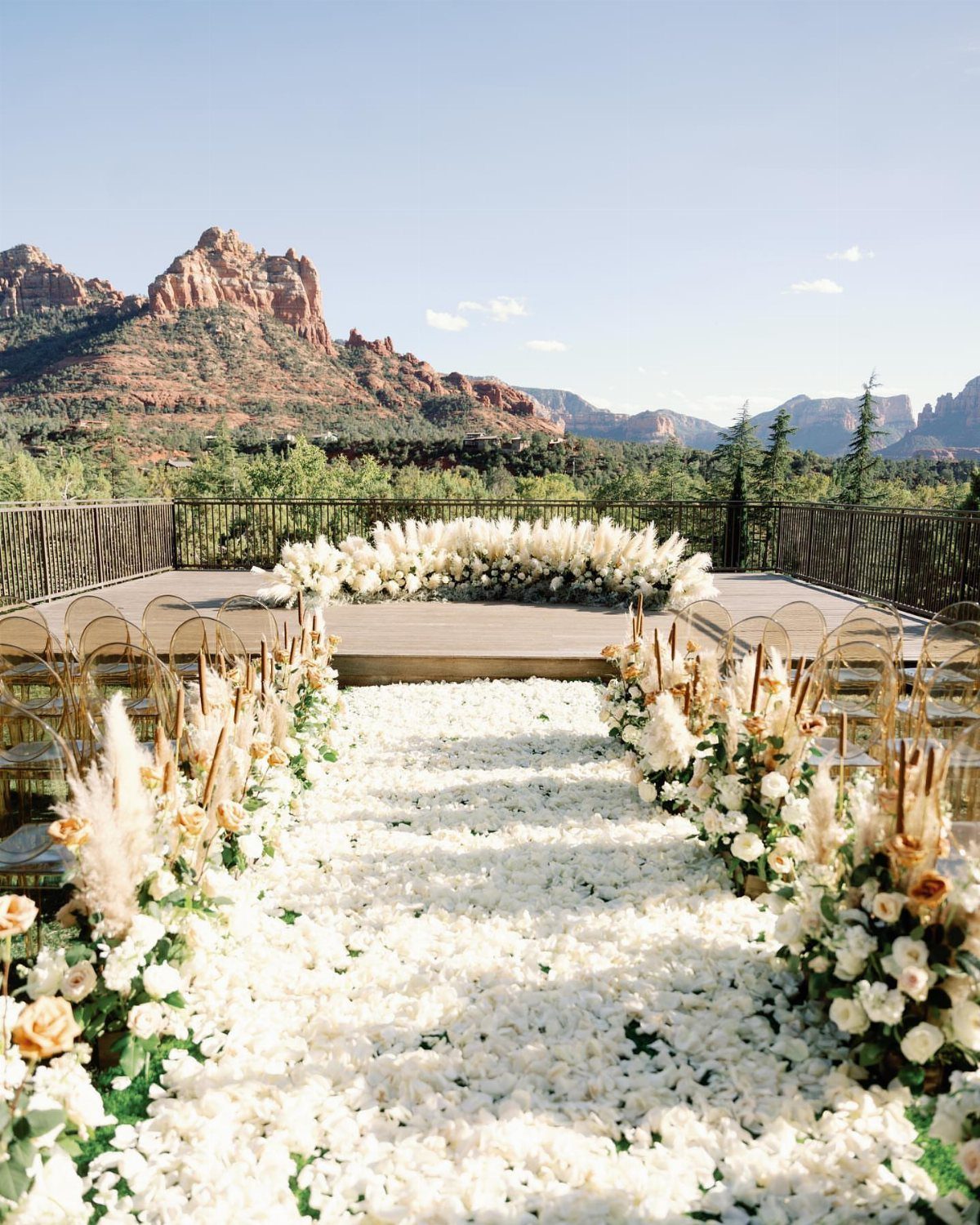Wedding ceremony terrace with white petal aisle and red rock mountain backdrop