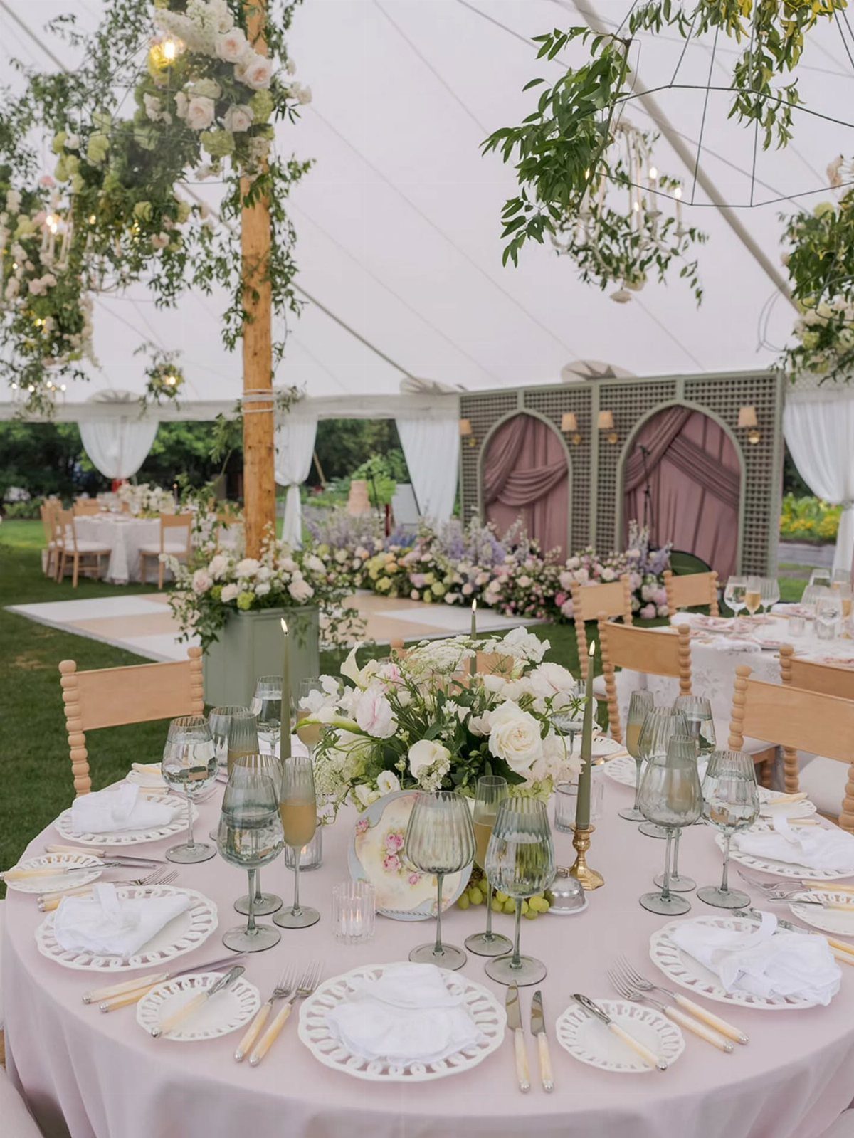Elegant wedding reception table with white flowers under a white event tent