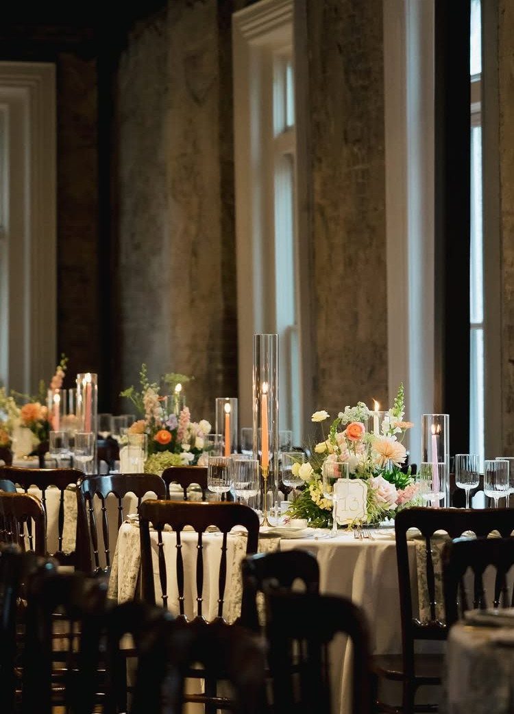 Elegant reception table with candles and flowers in a historic stone hall