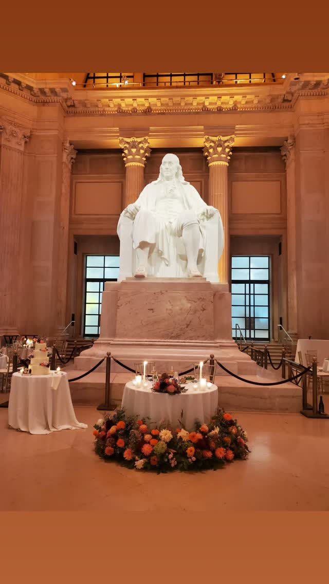 Grand museum hall with a large white statue and decorated reception tables.