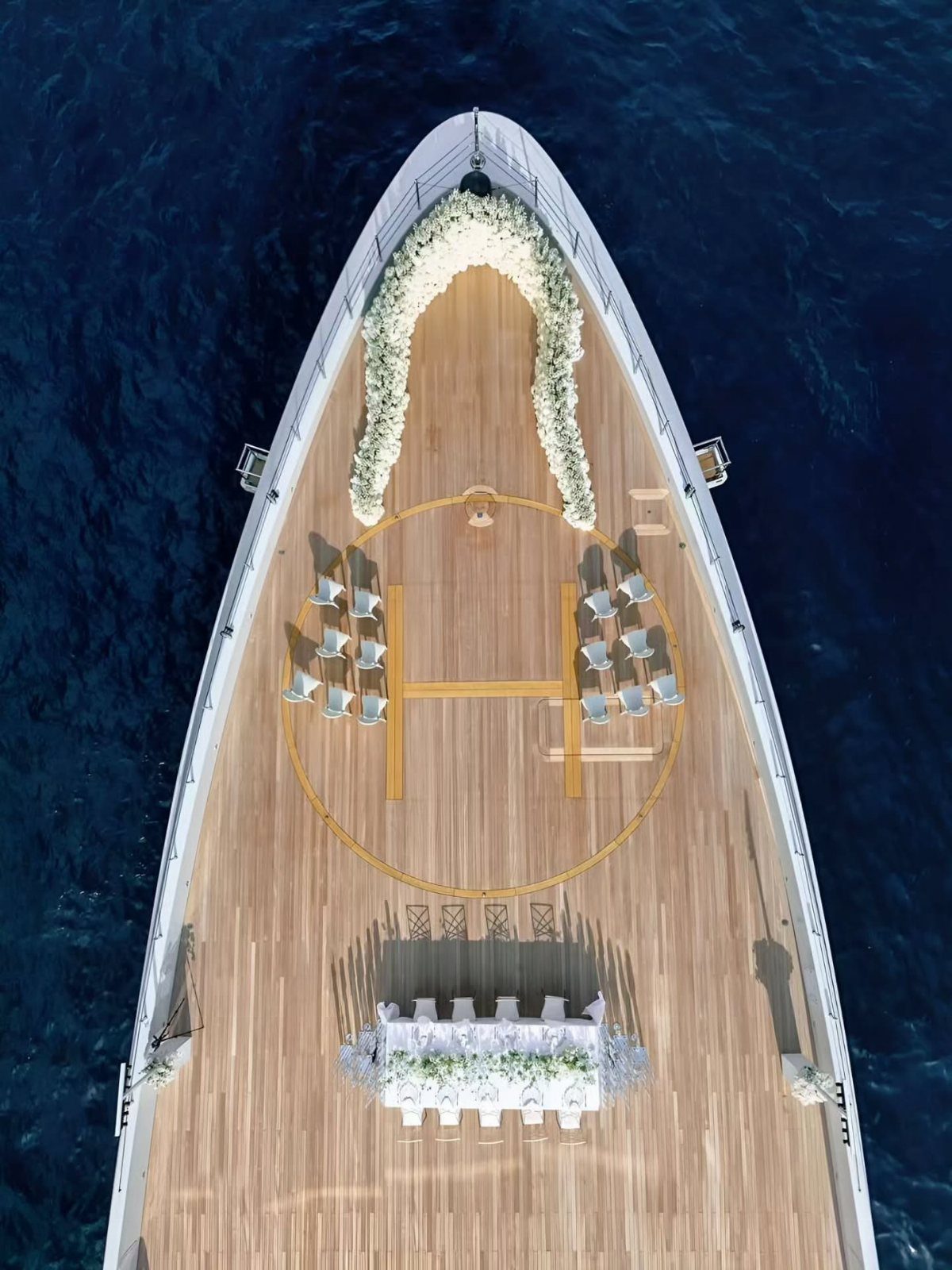 Wedding ceremony setup on the wooden deck of a white yacht on blue water