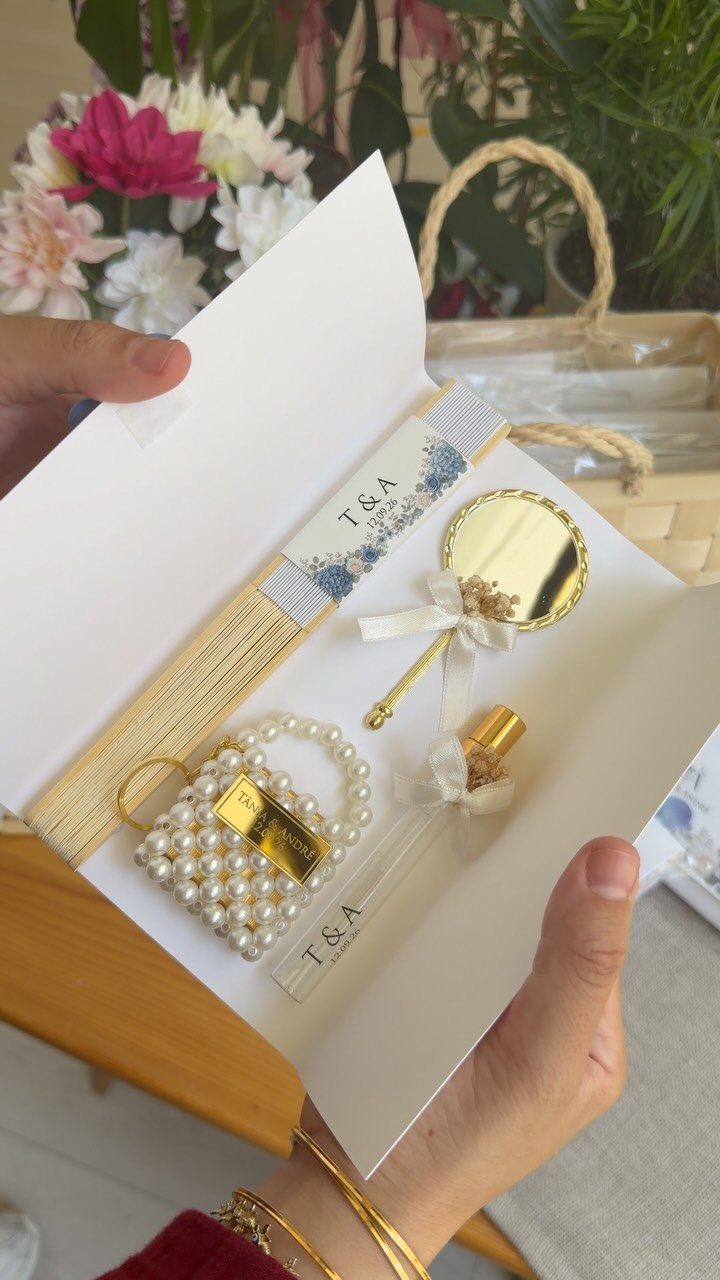 Wedding favor gift box with perfume, pearl accessory, and personalized T&A ribbon.