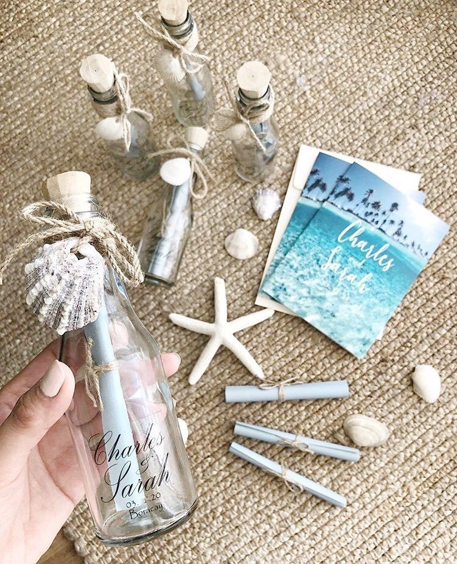 Glass bottle containing a rolled blue scroll tied with twine and a seashell