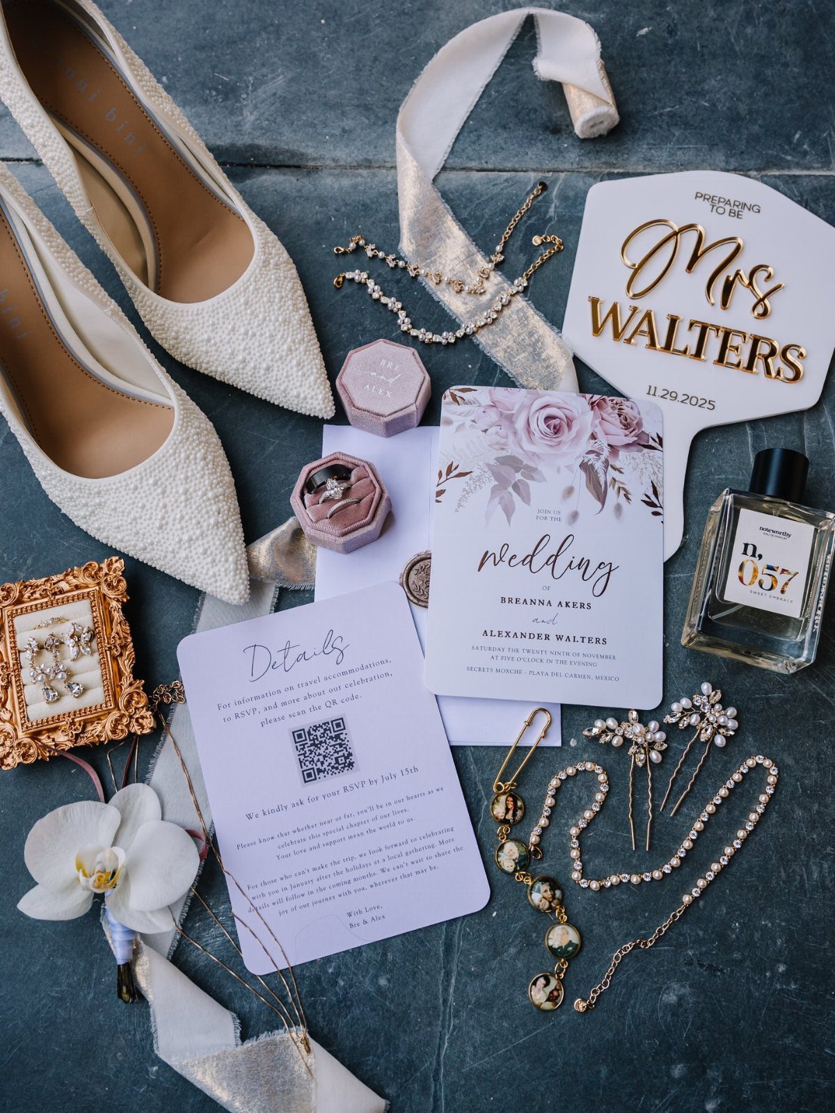 White bridal heels and gold jewelry arranged with a wedding invitation and accessories.