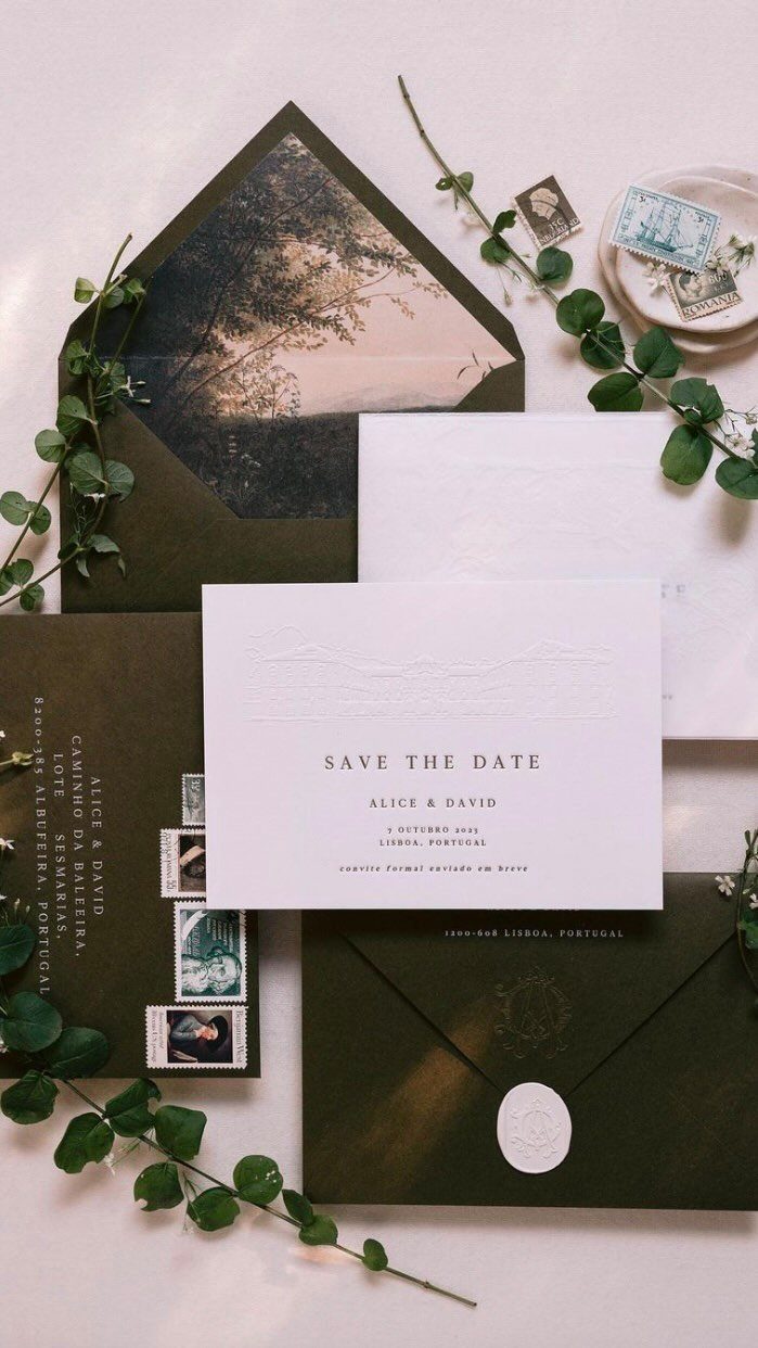 Wedding save the date card with dark green envelopes and green leafy branches.