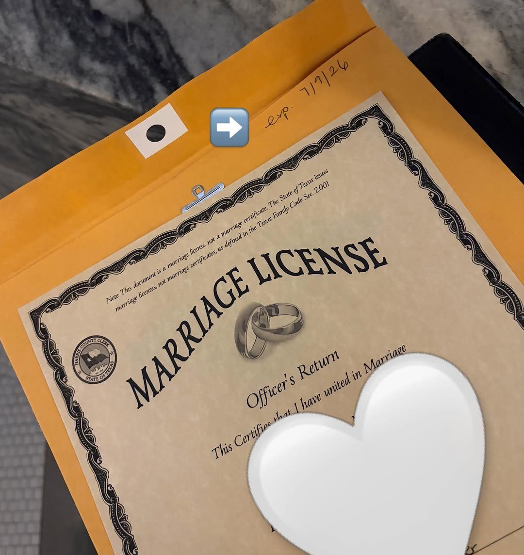 Marriage license document in a yellow folder with a white heart on top.