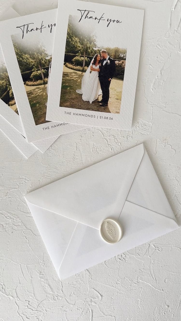 Wedding thank you cards with a couple's photo and a wax-sealed envelope.
