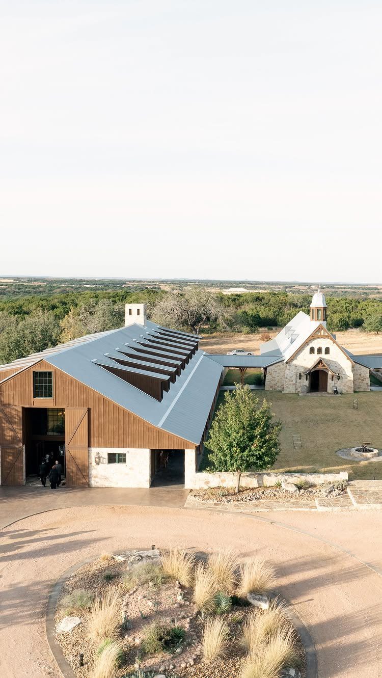 Rustic wooden barn and stone chapel in a rural countryside wedding venue setting.
