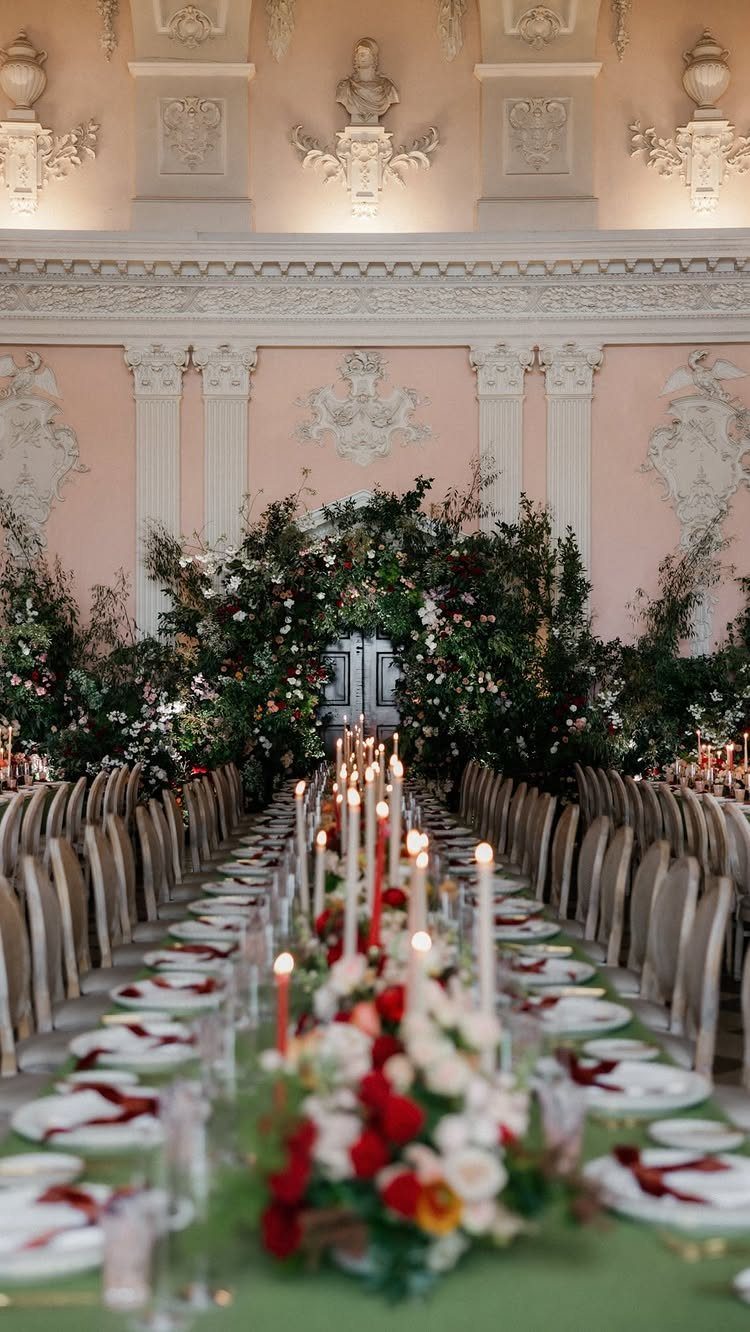 Long wedding table with candles and flowers in an ornate historical ballroom