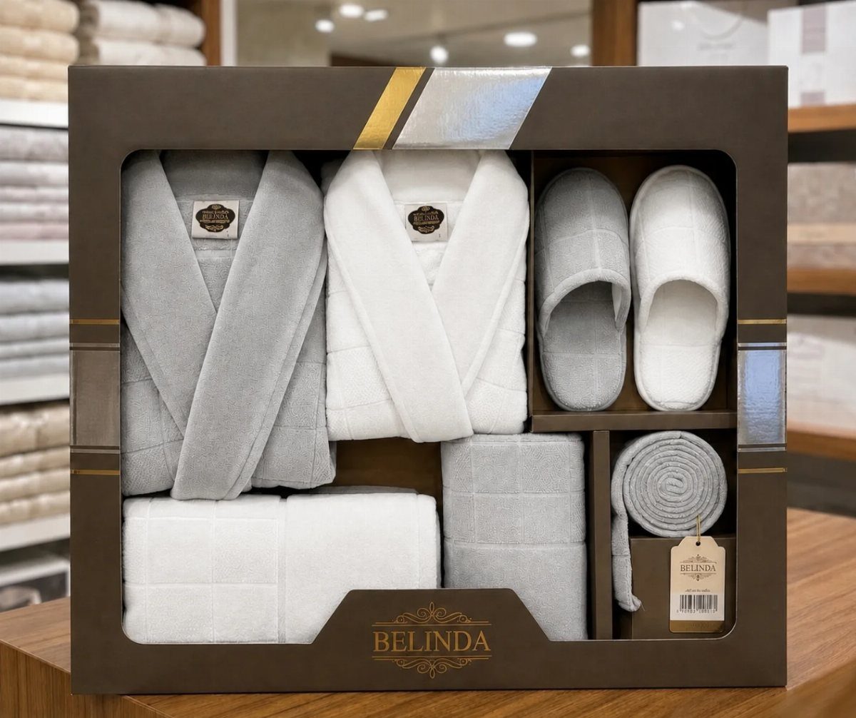 Bathrobe and towel gift set in grey and white inside a brown box.