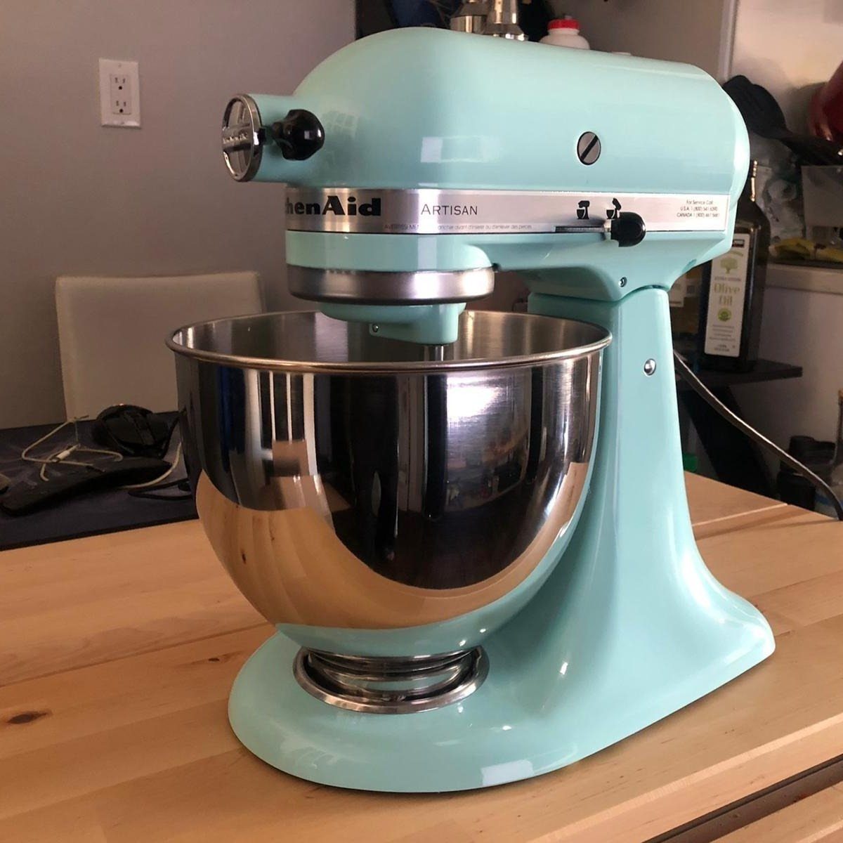 Light blue KitchenAid stand mixer with stainless steel bowl on wooden counter