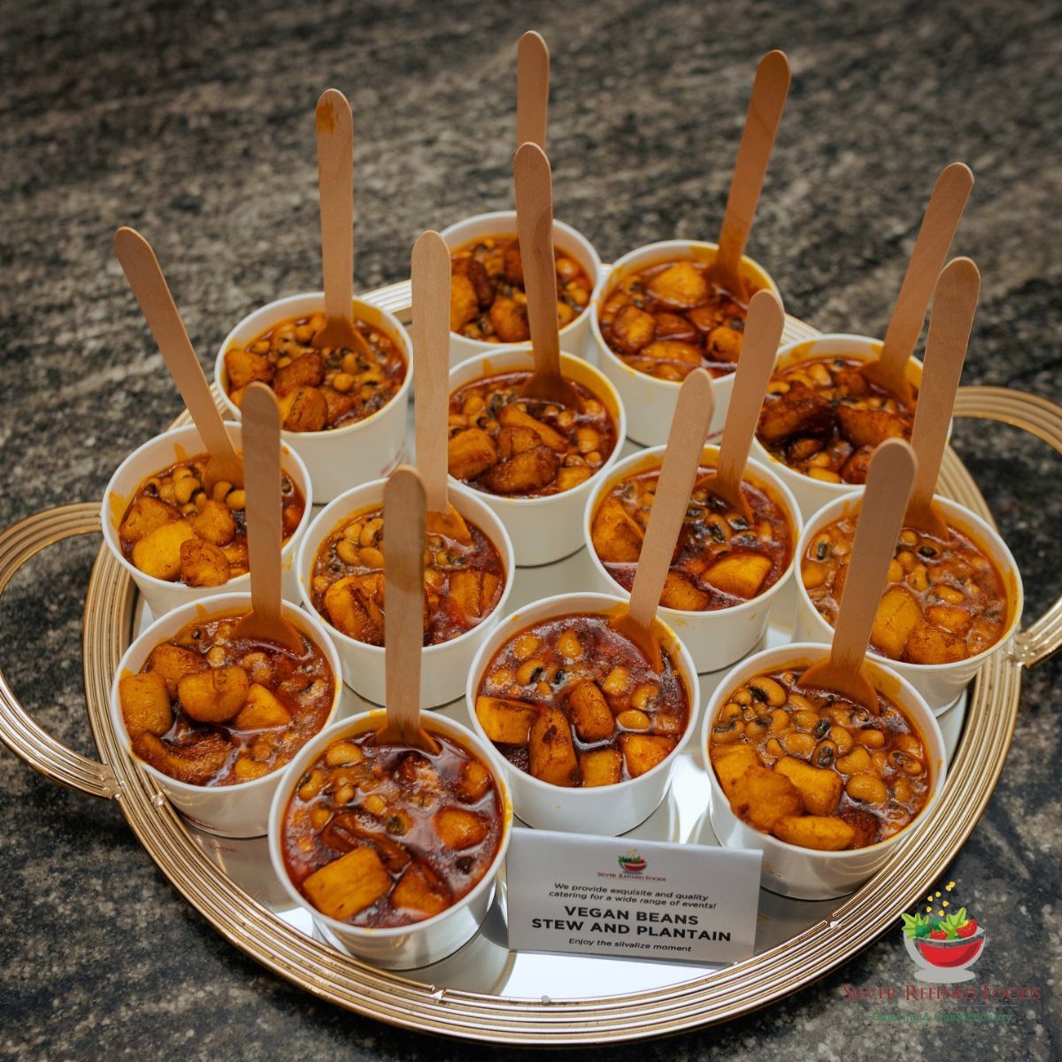 Vegan beans stew and plantain served in small white cups on a tray.
