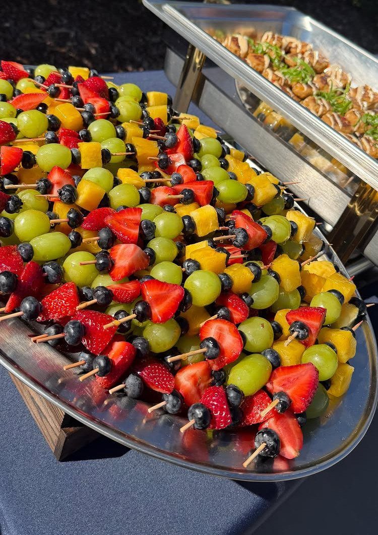 Fruit skewers with strawberries, grapes, and mango on a silver platter.