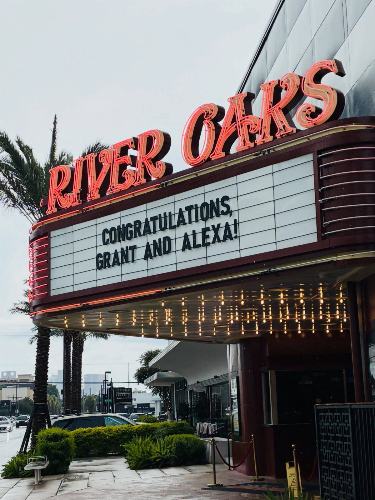 Theater marquee with red neon signs and a congratulatory message for a couple.
