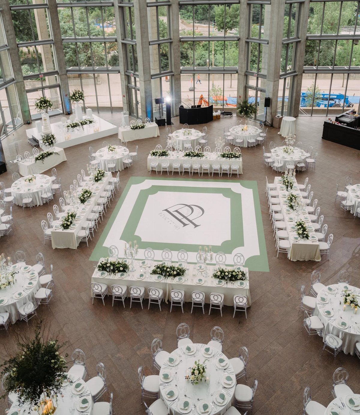 Wedding reception hall with white tables and a monogrammed dance floor