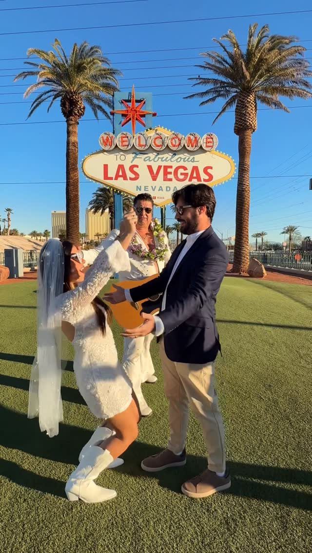 Couple exchanging vows in front of the Welcome to Fabulous Las Vegas sign.